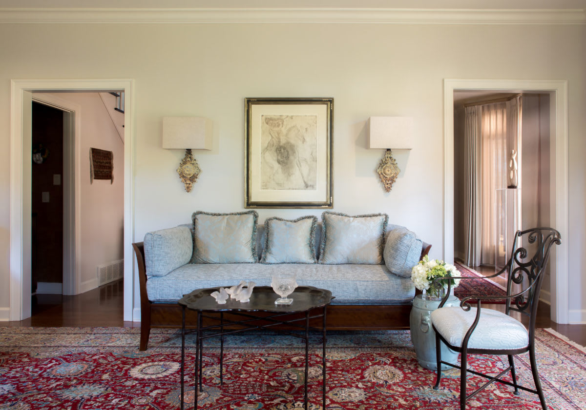Elegant living room with a sofa, artwork, and a decorative coffee table.
