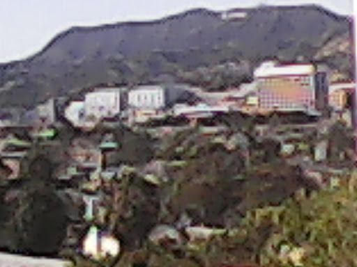 A view of a hilly landscape with buildings in the background.