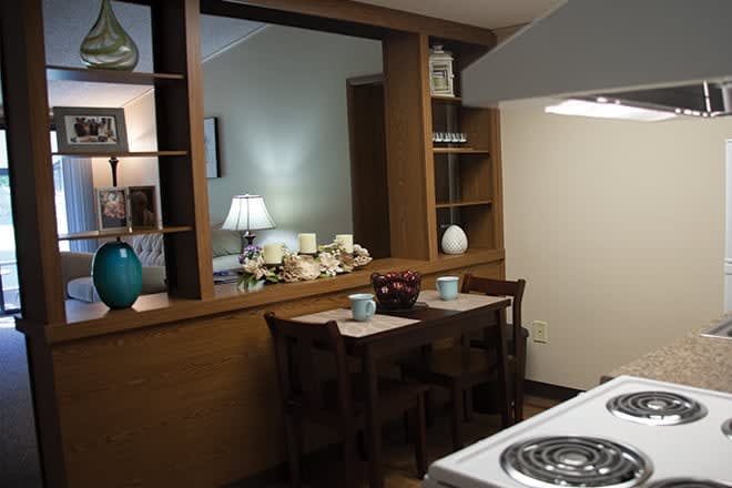 A cozy kitchen with a small dining area featuring wooden furniture and decor.