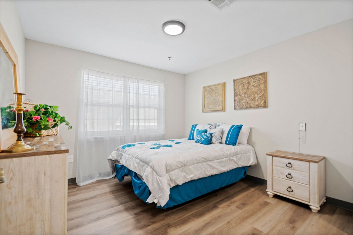 A bright and cozy bedroom with a neatly made bed and minimalist decor.