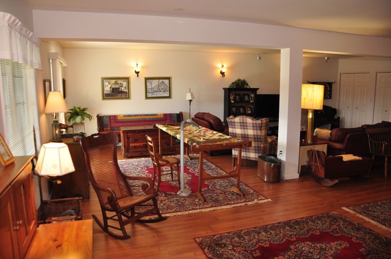 A cozy living room with a warm interior design, featuring wooden floors, rugs, and classic furniture.