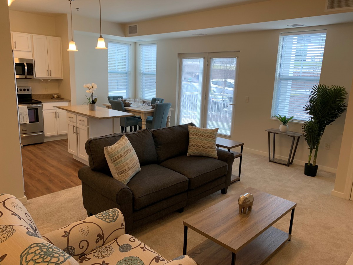 A modern, open-concept living room with a comfortable sofa and kitchen island.