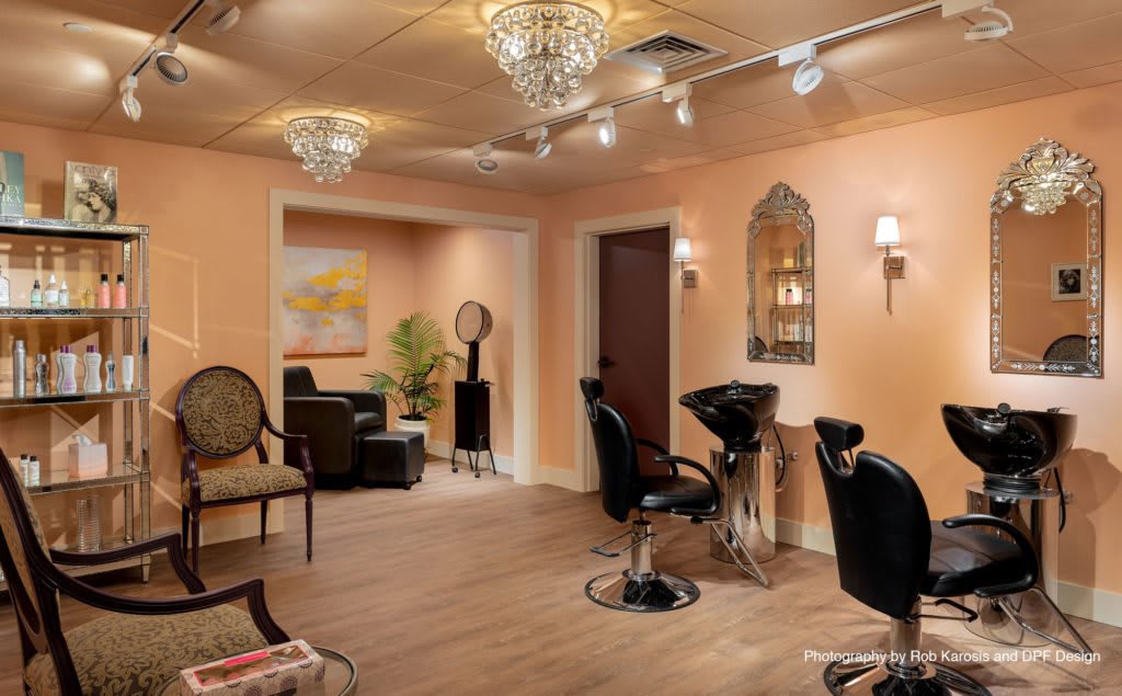 A beautifully decorated salon interior with elegant lighting and comfortable seating.
