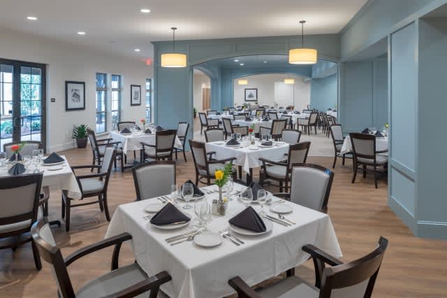 An elegant dining room with neatly arranged tables and chairs, set for a meal.