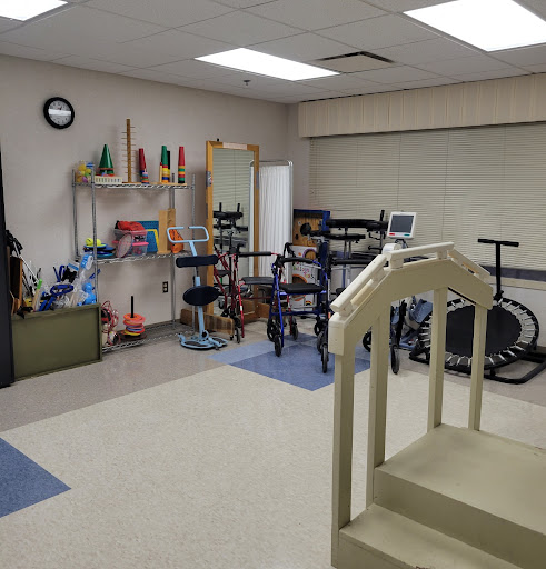 A well-equipped therapy room featuring various exercise and rehabilitation equipment.