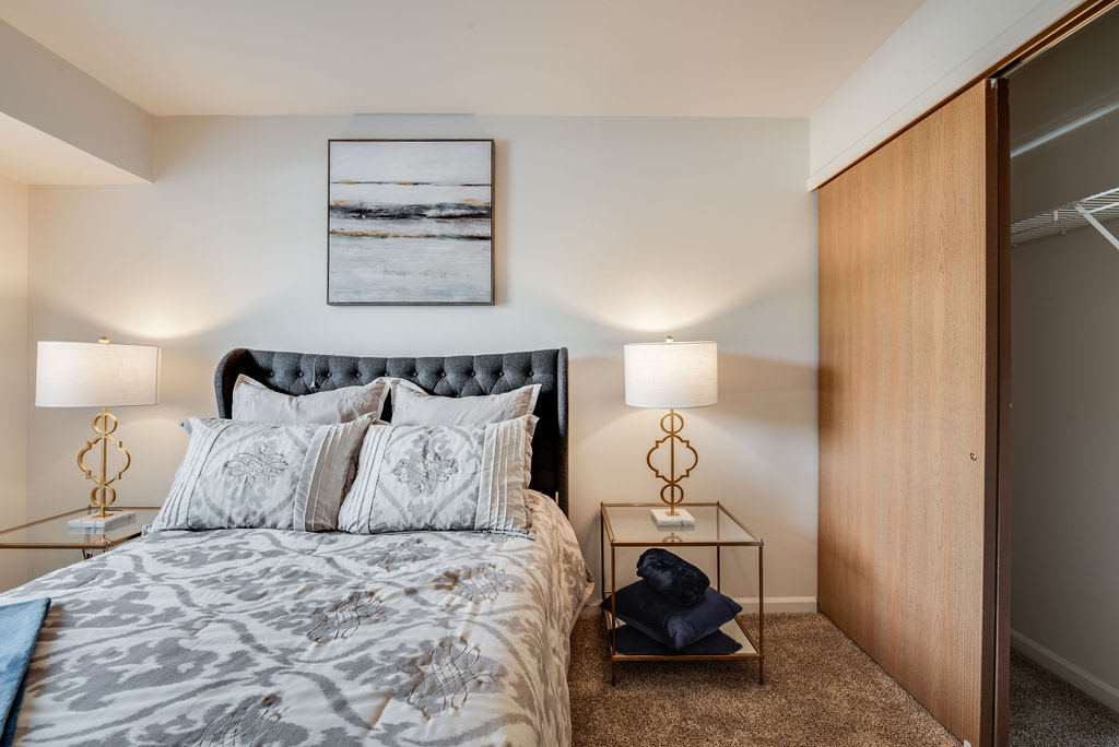 A cozy bedroom with a stylish bed, modern nightstand, and elegant decor.