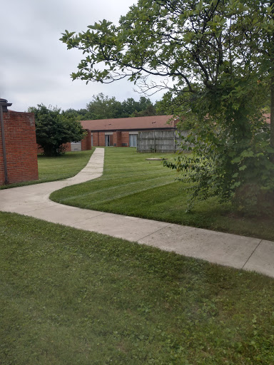 A serene view of a landscaped area featuring a winding pathway and well-manicured grass.