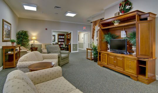 A cozy living room with comfortable seating and a wooden entertainment center.