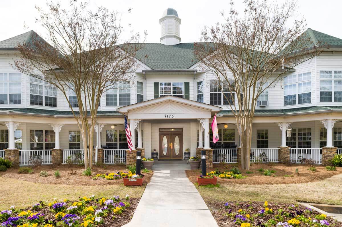A spacious two-story colonial-style house with a landscaped front yard.