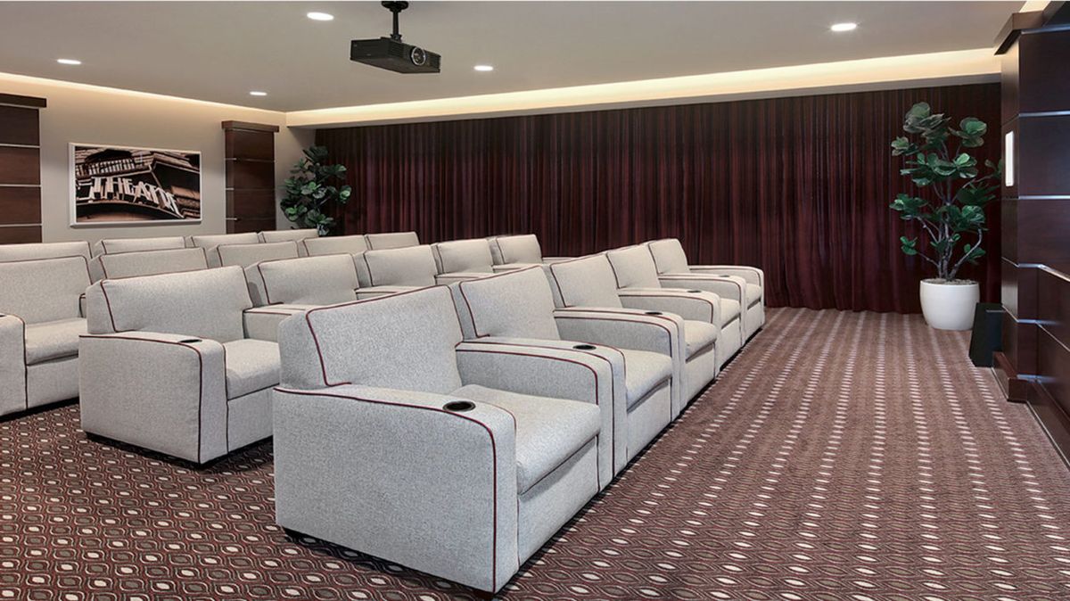 A modern home theater setup with comfortable recliner seating and a projector.