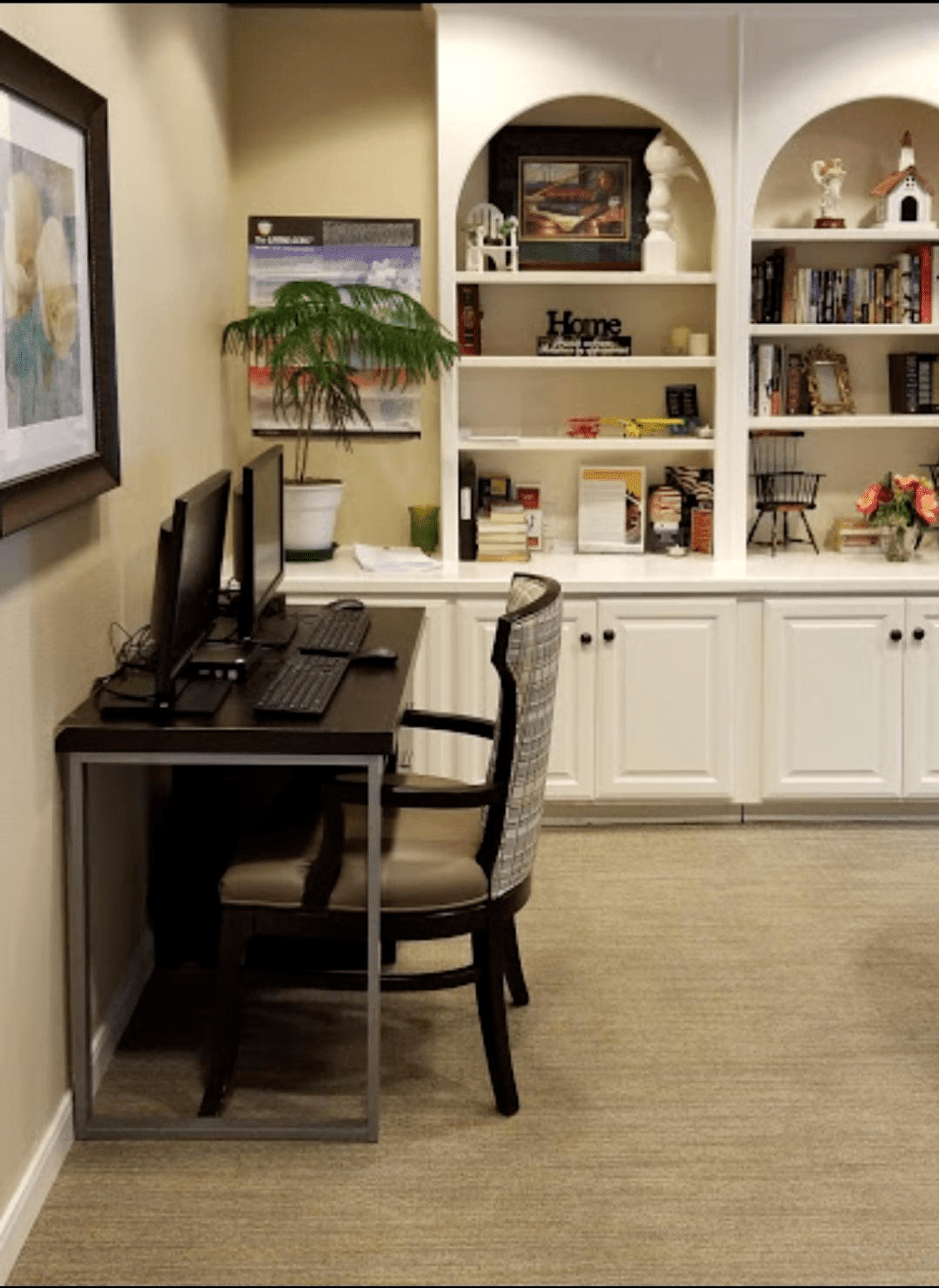 A cozy home office setup with a desk, computer, and bookshelf.
