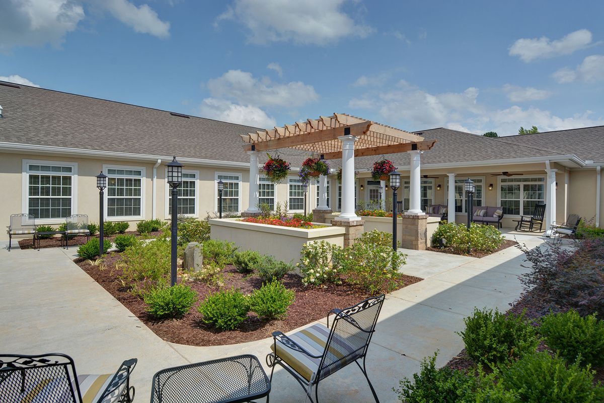 A beautifully landscaped courtyard with outdoor seating and a pergola.