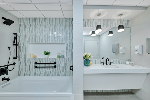 A contemporary bathroom featuring a stylish tub and modern vanity with elegant lighting.