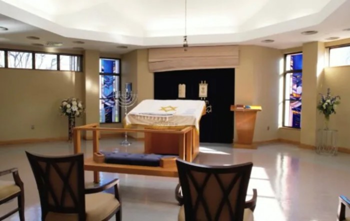 Interior view of a synagogue with a pulpit and Torah scrolls.