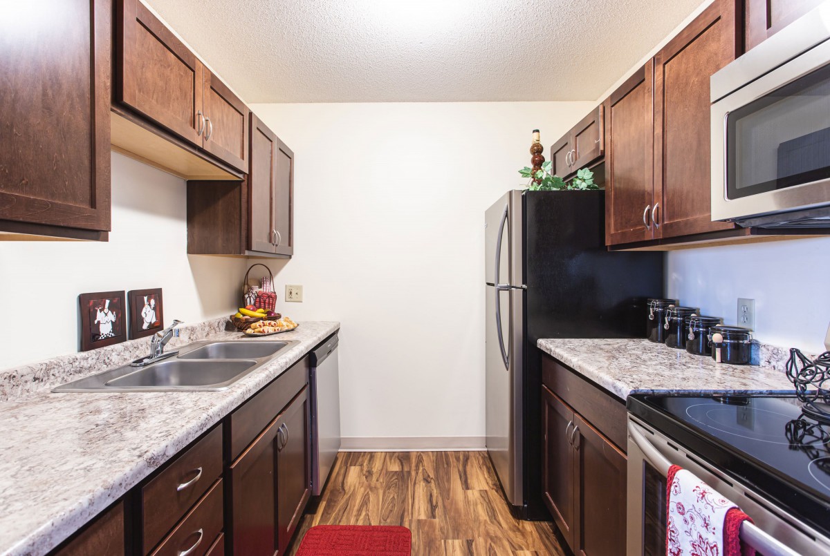 A modern kitchen with wooden cabinets and stainless steel appliances.