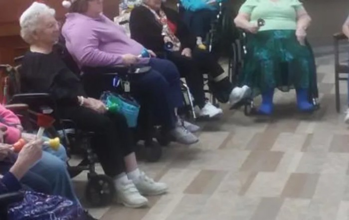 A group of people sitting in wheelchairs indoors.