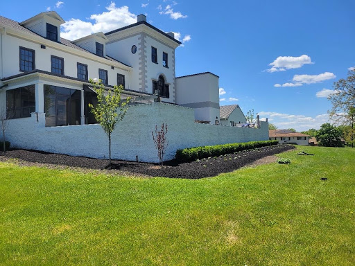 A beautifully designed house with modern architecture, surrounded by well-maintained landscaping and under a clear blue sky.