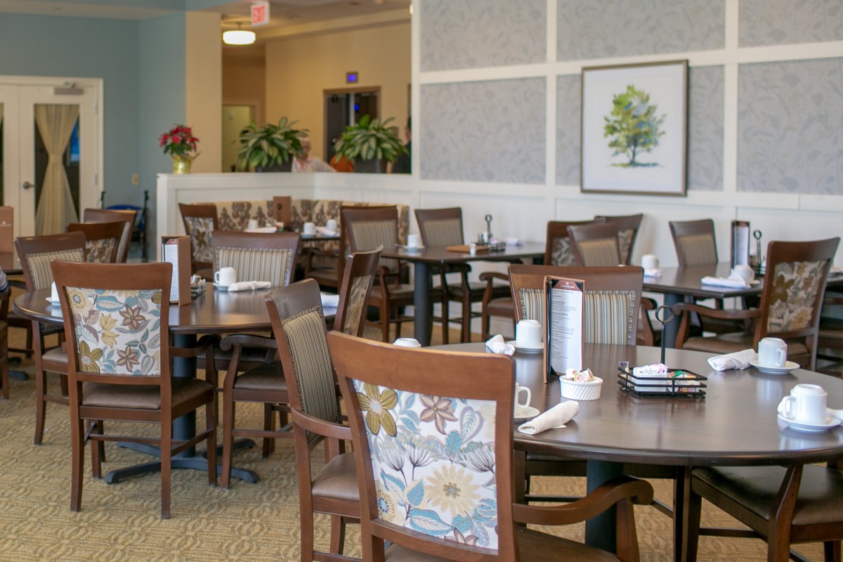 A well-decorated dining area with several empty tables and chairs.