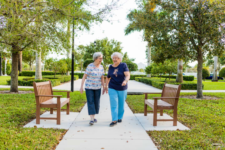 Two elderly women enjoying a walk together in the park.