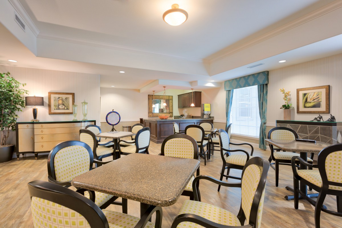 A bright and inviting dining area featuring multiple tables and chairs, with elegant decor and ample natural light.