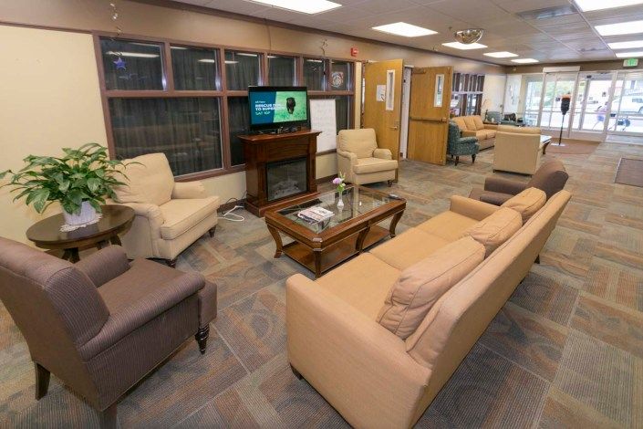 A cozy living room with sofas, chairs, and a television.
