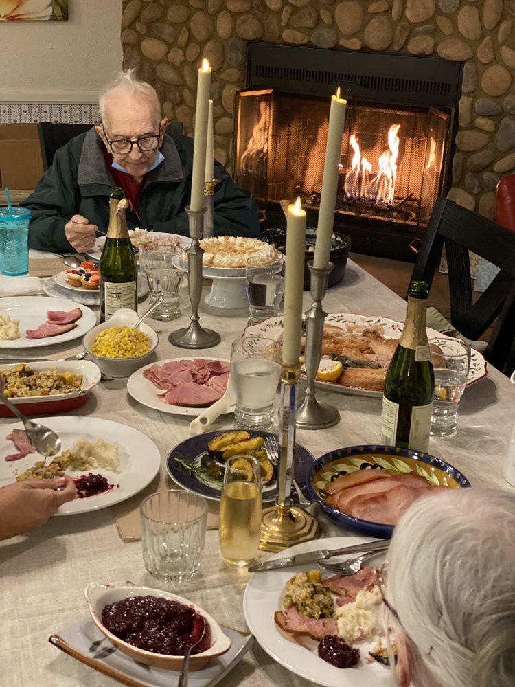 A cozy family dinner with candles and a warm fireplace.