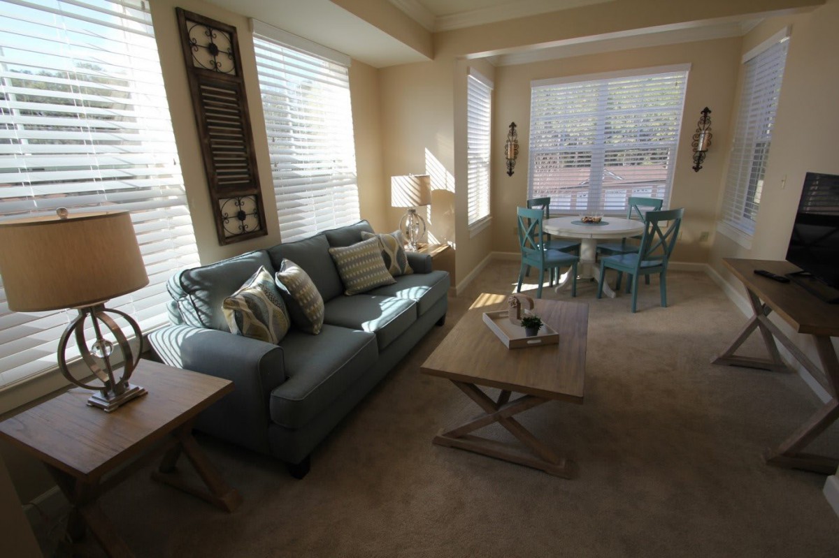 A cozy living room with a sofa, coffee table, and adjoining dining area.