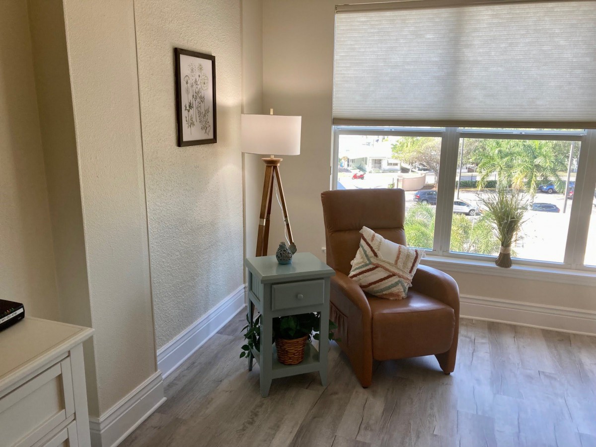 A cozy living room corner with a leather armchair and side table by the window.