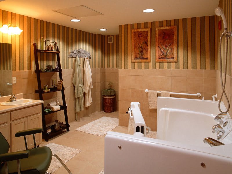 A modern bathroom with a walk-in bathtub, striped wallpaper, and a ladder shelf holding towels.