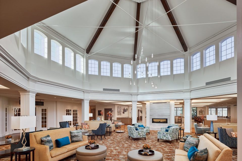 A spacious, well-lit lobby with modern seating and a large chandelier.