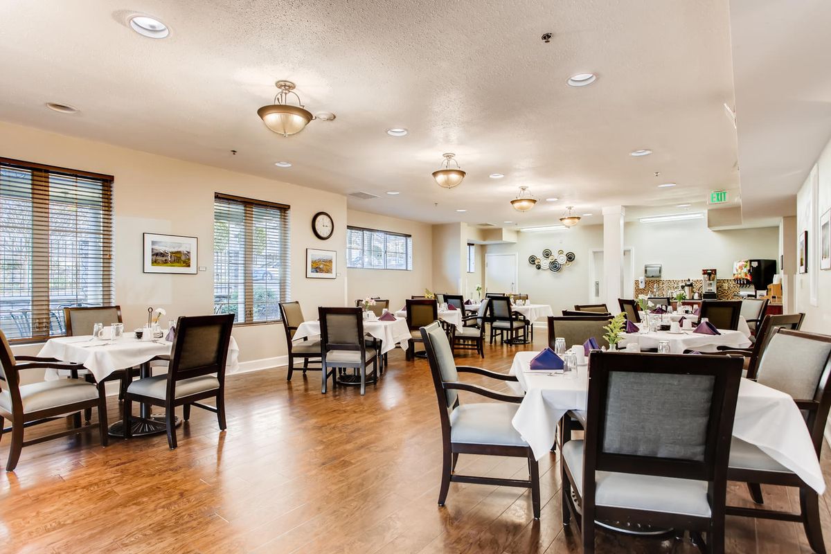 A well-lit dining room with neatly arranged tables and chairs, featuring a warm and inviting decor.