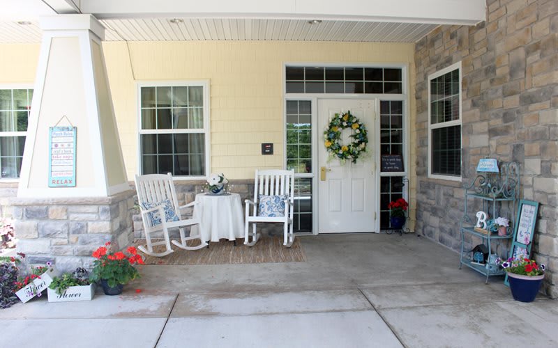 A welcoming front porch with rocking chairs and a wreath on the door.