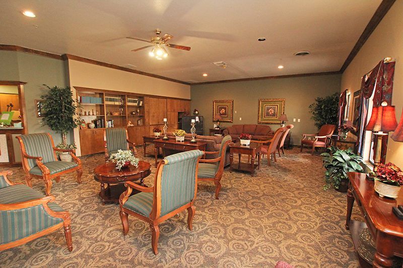 A cozy lounge area with wooden furniture and decorative plants.