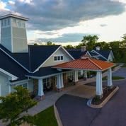 A beautifully designed building with a unique roof structure under a cloudy sky.