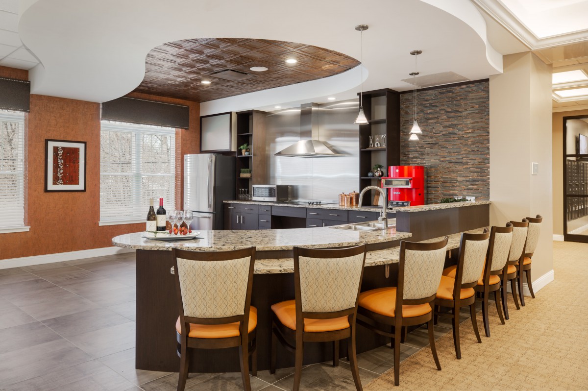 A modern kitchen with a bar-style countertop and stylish seating.