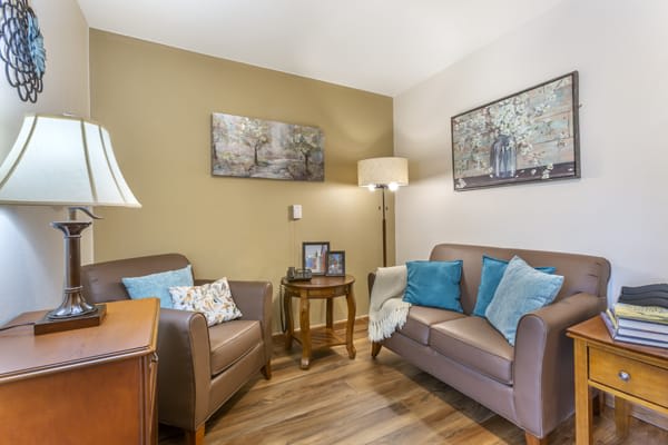 A cozy living room with a sofa, armchair, and decorative elements.