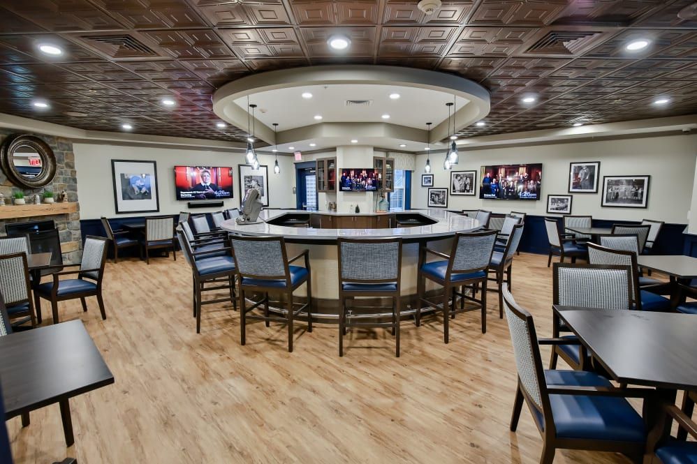 A modern bar with circular seating and multiple televisions on the walls.
