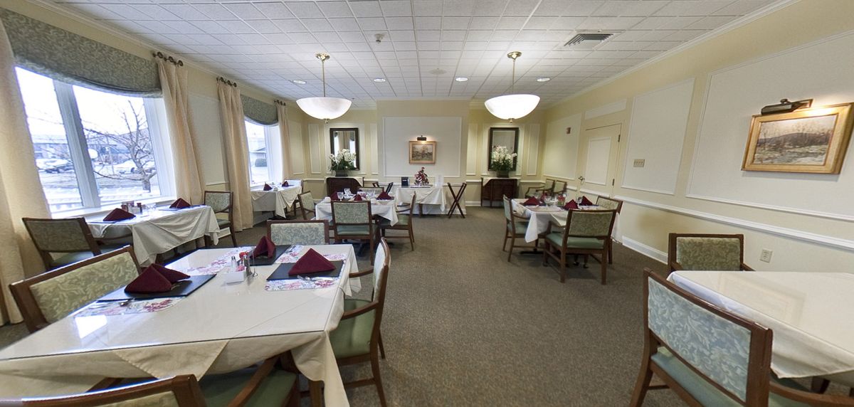 An elegant dining room setup with neatly arranged tables and chairs.