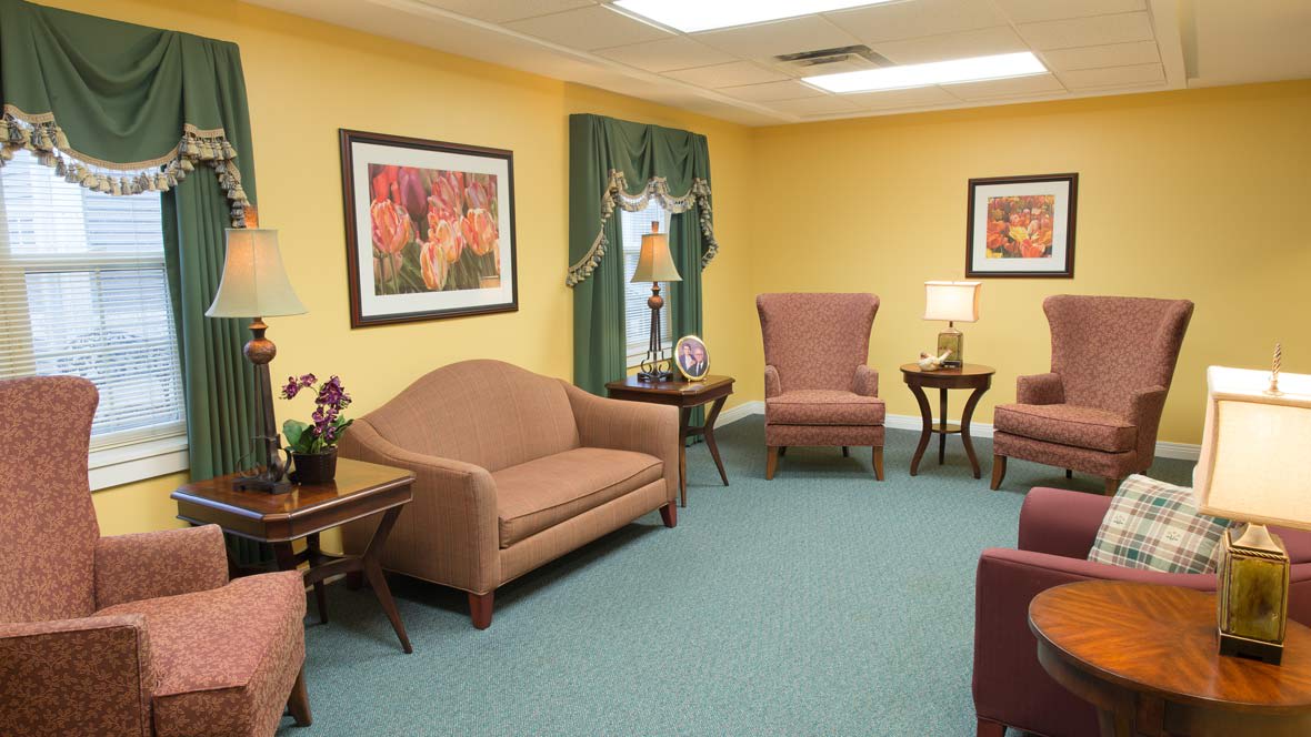 A well-furnished living room with sofas, armchairs, tables, and lamps.
