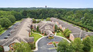 Aerial view of a large residential building complex surrounded by trees.