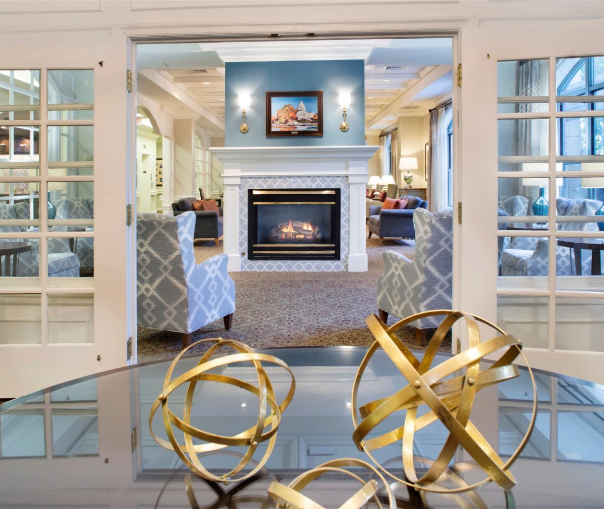 A modern living room with a fireplace and geometric sculptures in the foreground.