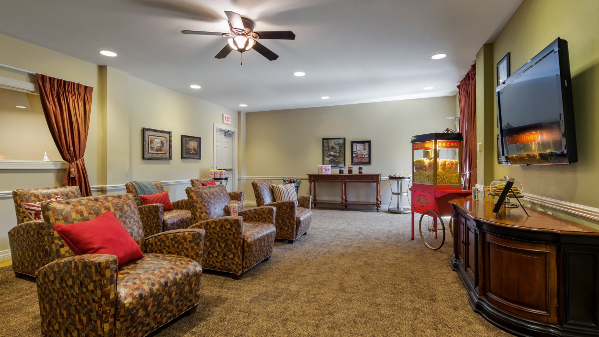 A cozy home theater with comfortable seating and a popcorn machine.