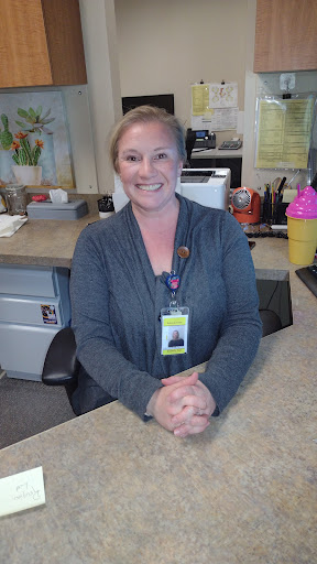 A cheerful receptionist welcoming visitors at her desk.