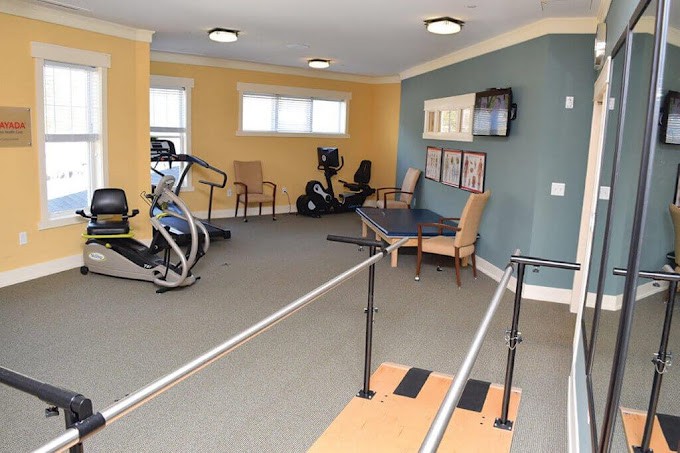 A fitness room equipped with exercise machines and rehabilitation parallel bars.
