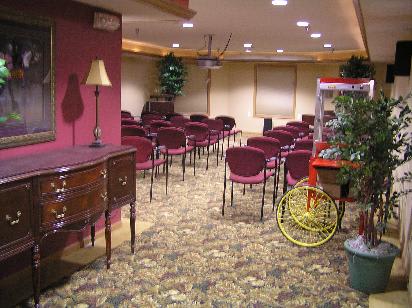 An empty conference room set up with rows of chairs and a projector.
