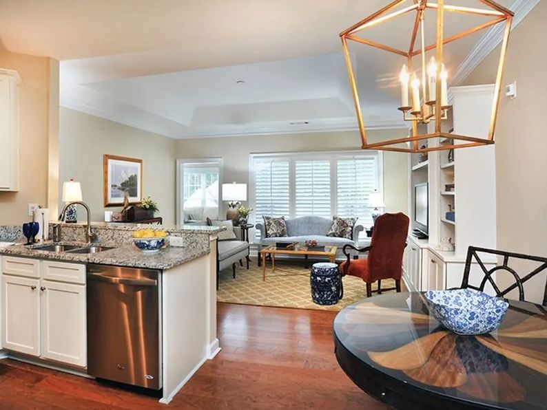 Open concept kitchen and living room with modern decor and hardwood floors.