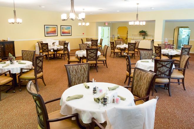 A neatly arranged dining room with tables and chairs, ready for guests.