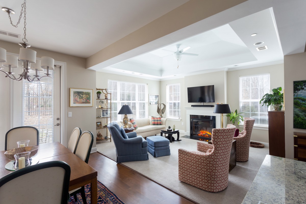 A cozy and elegantly furnished living room with a fireplace and ample natural light.