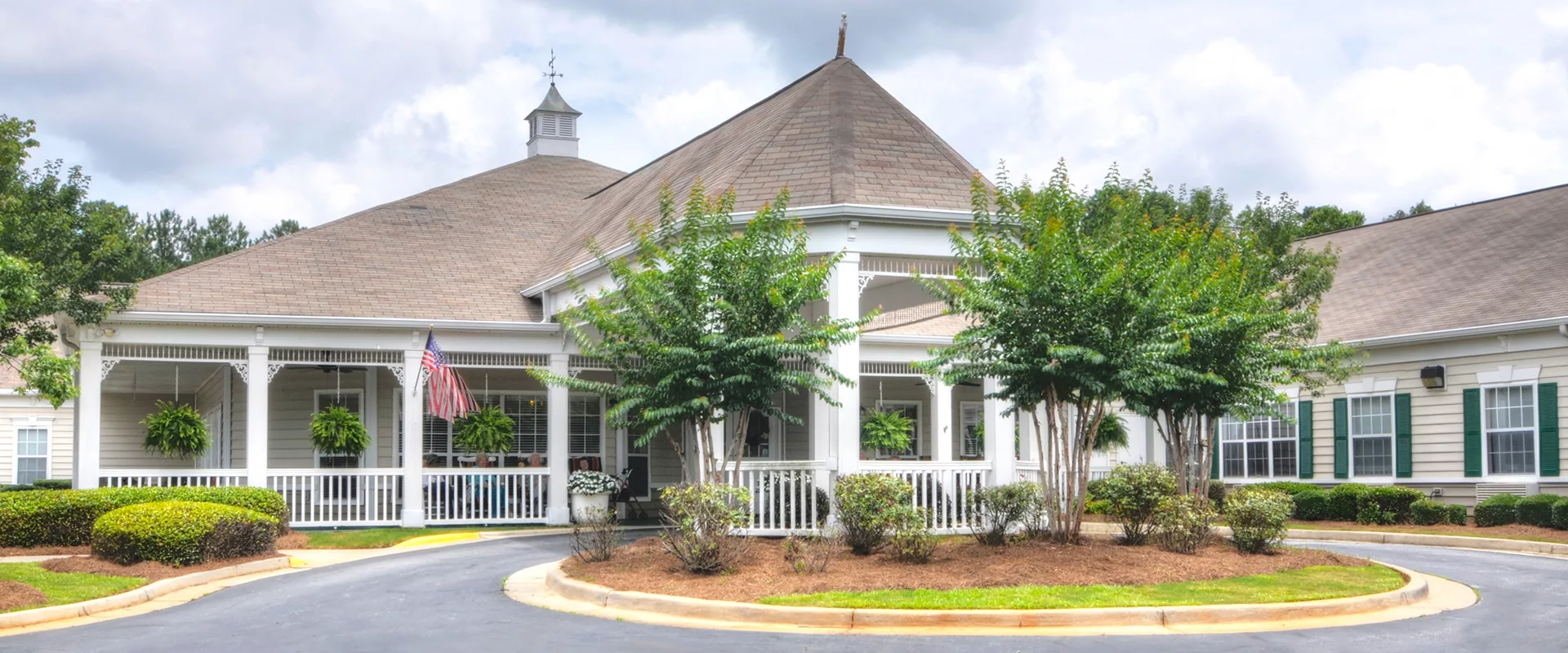 A picturesque gazebo surrounded by trees and a well-maintained garden.