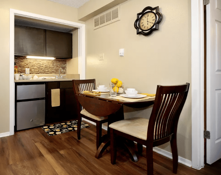 A cozy dining area with a wooden table and chairs adjacent to a modern kitchen.